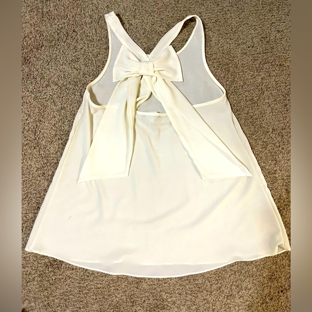 Sheer cream colored top with bow in the back